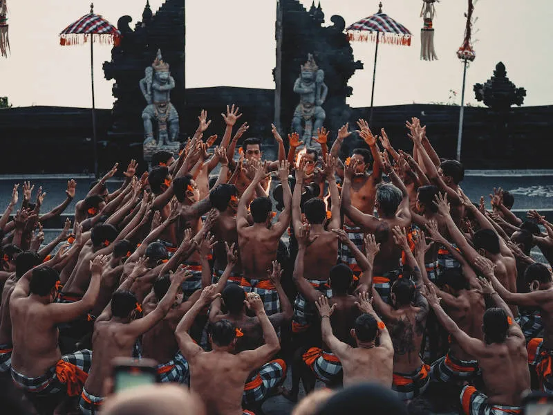 a group of men performin a Kecak Dance in the Uluwatu temple